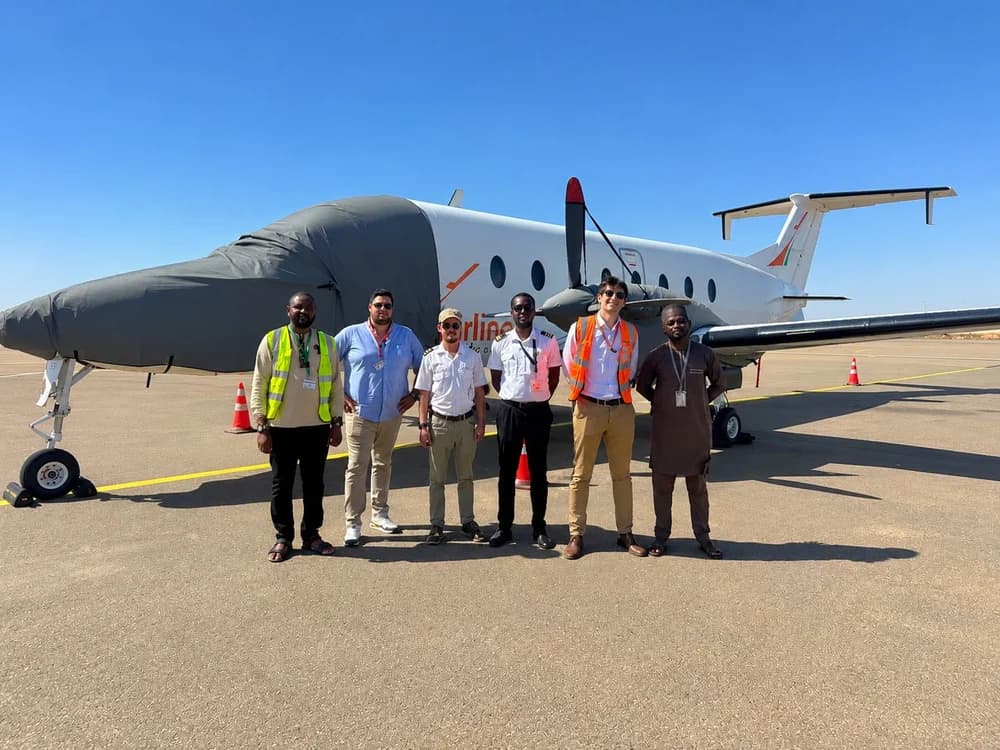 Laurent Travostino with a client team in front of a Beechcraft 1900 turboprop on the apron